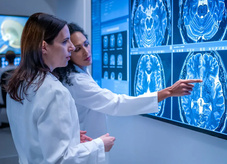 Two medical professionals analyze brain scans
